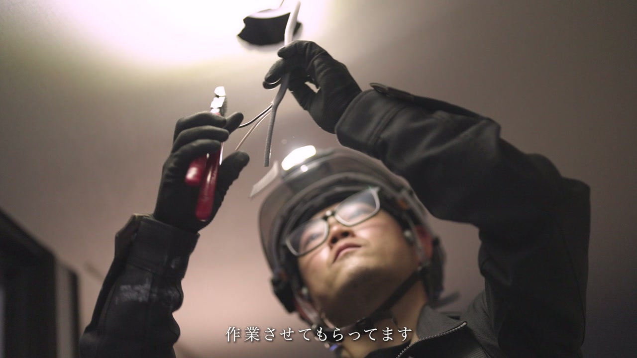 見上げながら配線作業を行う電気工事士 ／「作業させてもらってます」