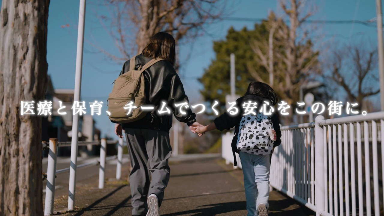 手をつないで歩く親子 ／「医療と保育、チームでつくる安心をこの街に。」